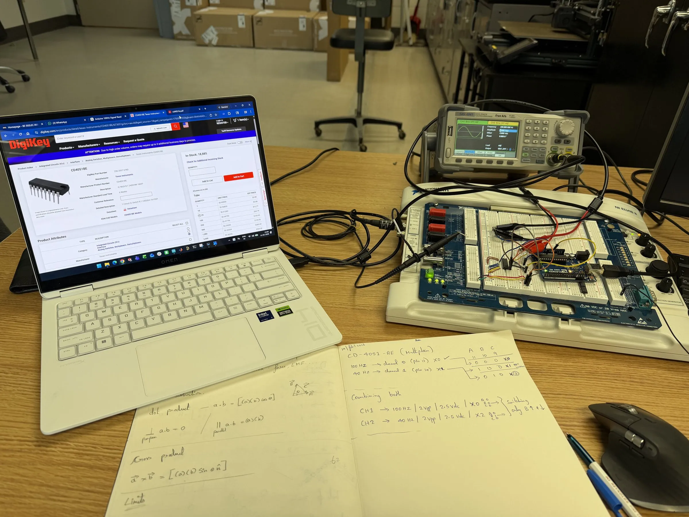 Lab bench with a laptop, function generator and breadboard circuit