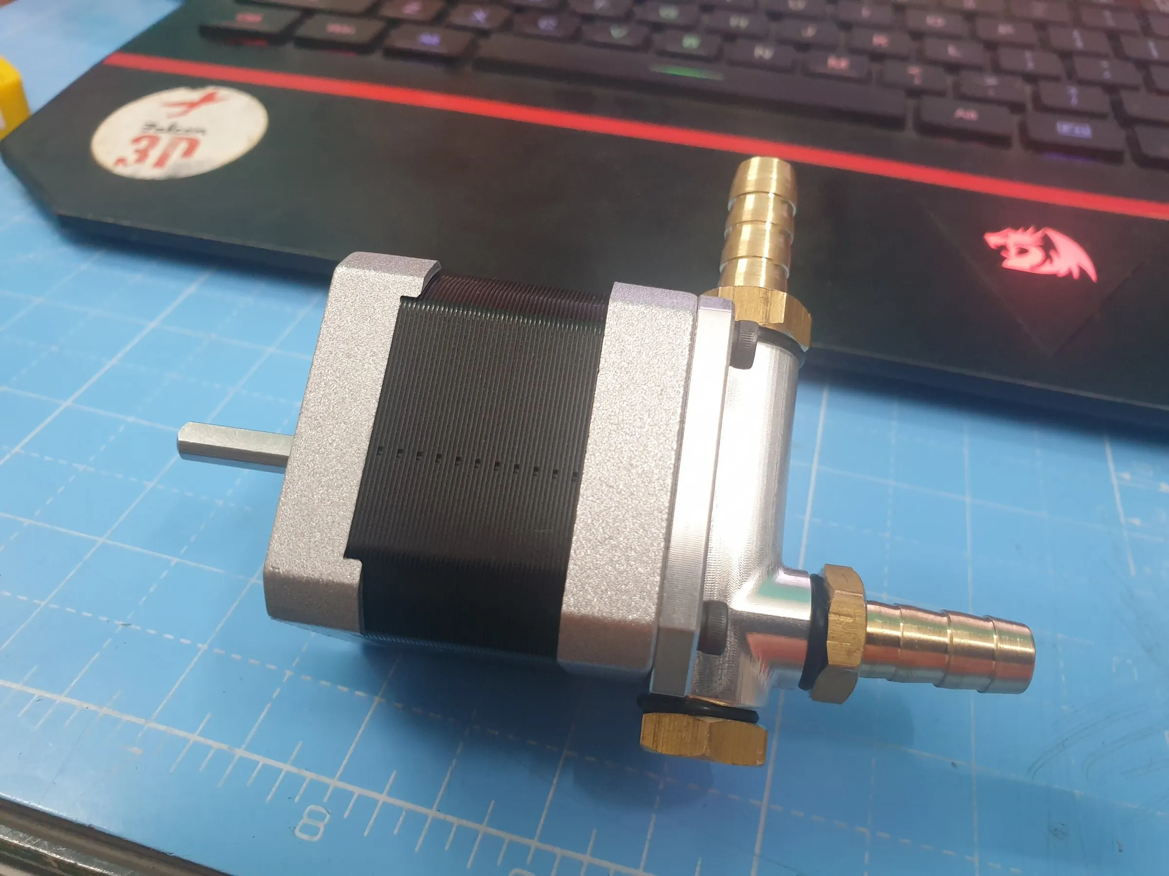 Stepper motor with an aluminum water-cooling block and brass fittings