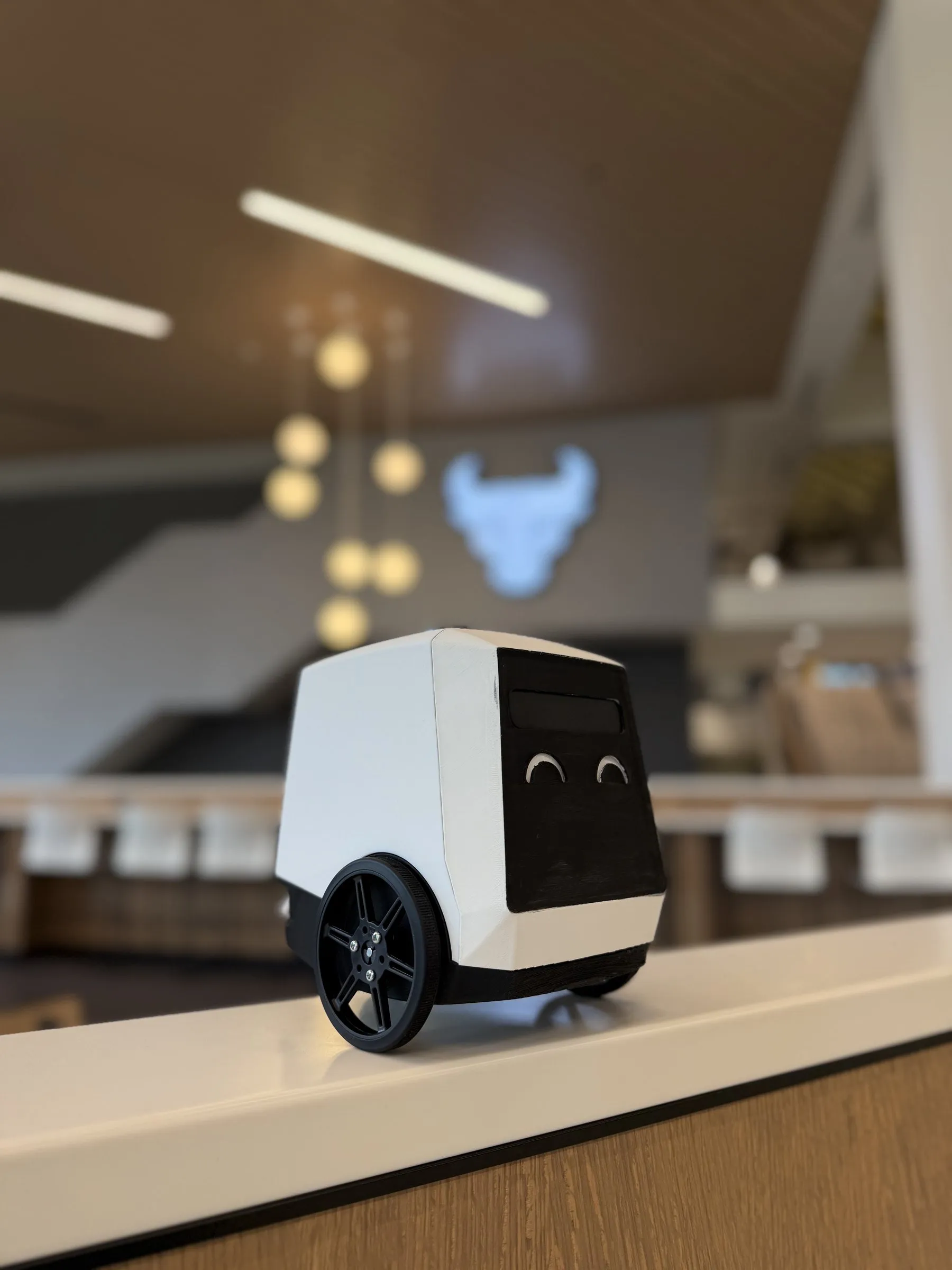 Pebble, a small white robot with a face display, on a counter at the University at Buffalo