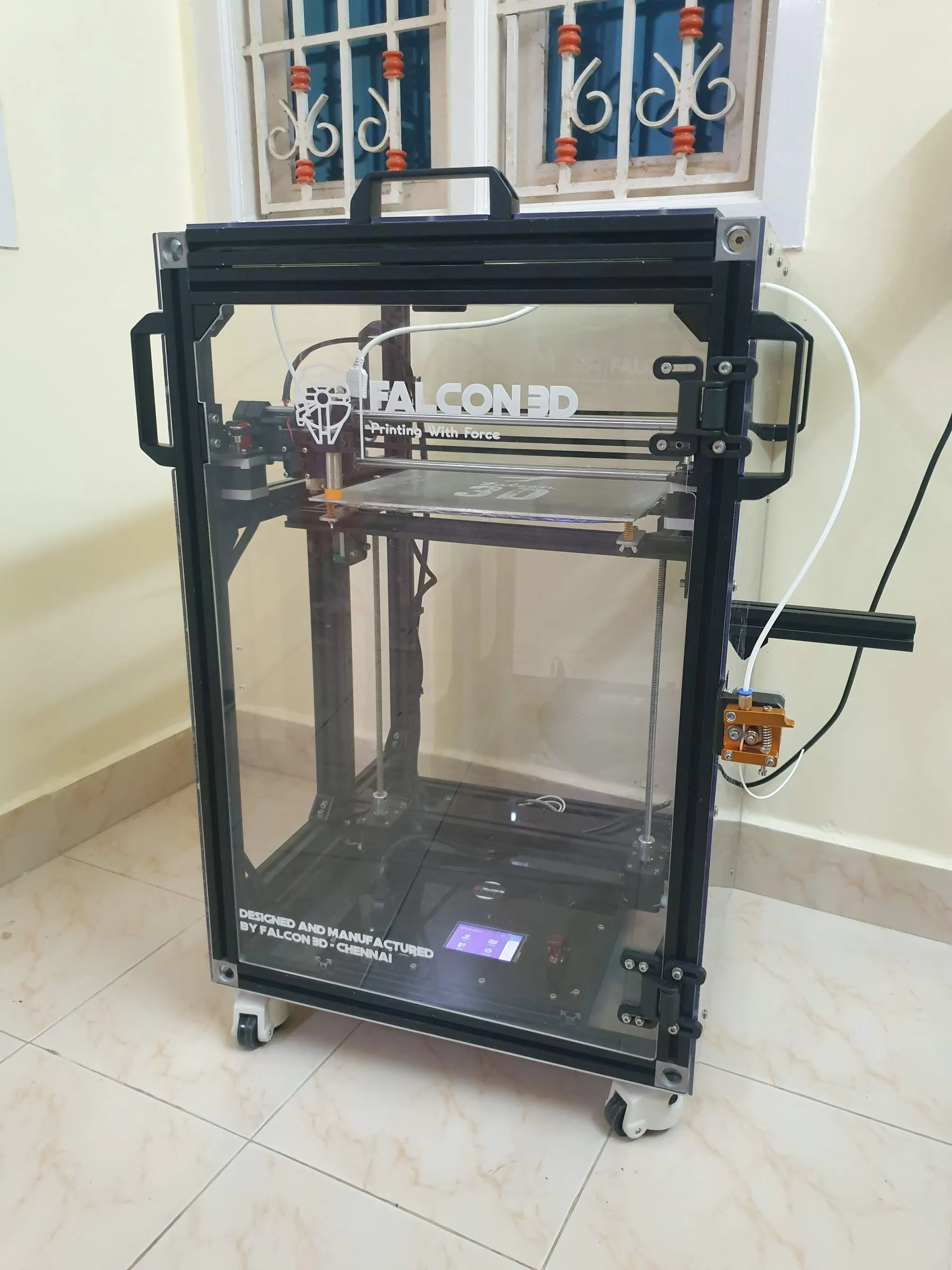 An enclosed Falcon 3D printer with the Falcon 3D logo on its front panel