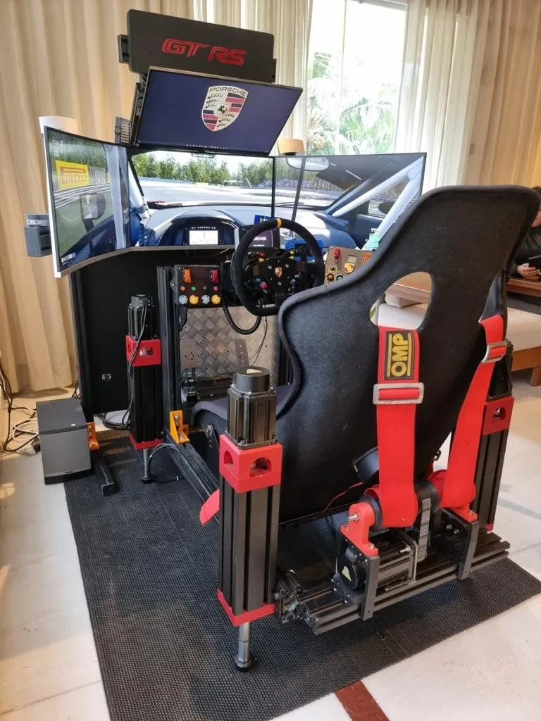 A full racing-simulator rig with a bucket seat, wheel and screens, mounted on the actuators