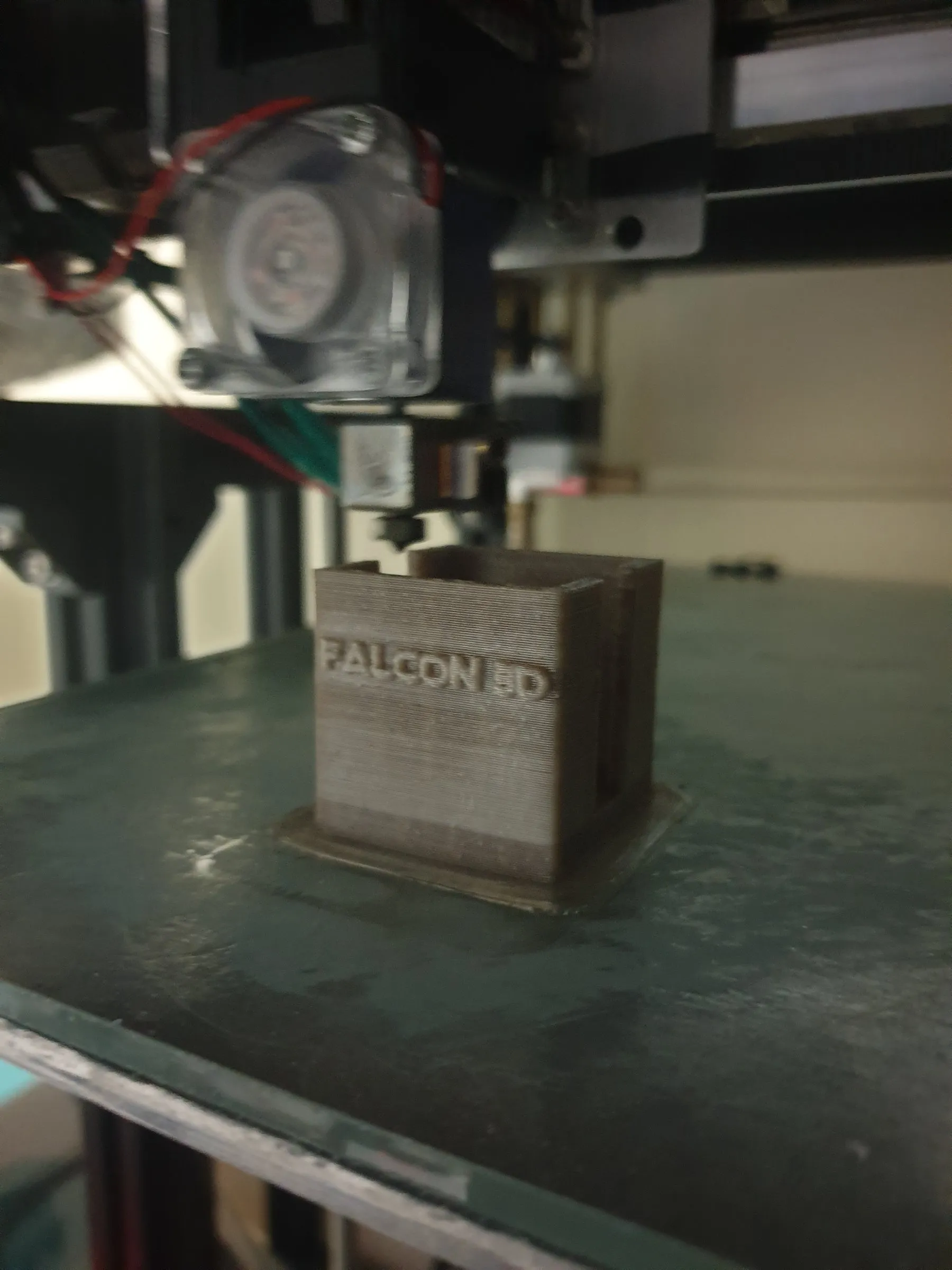 A brown PEEK box with the Falcon 3D logo, printed on the machine