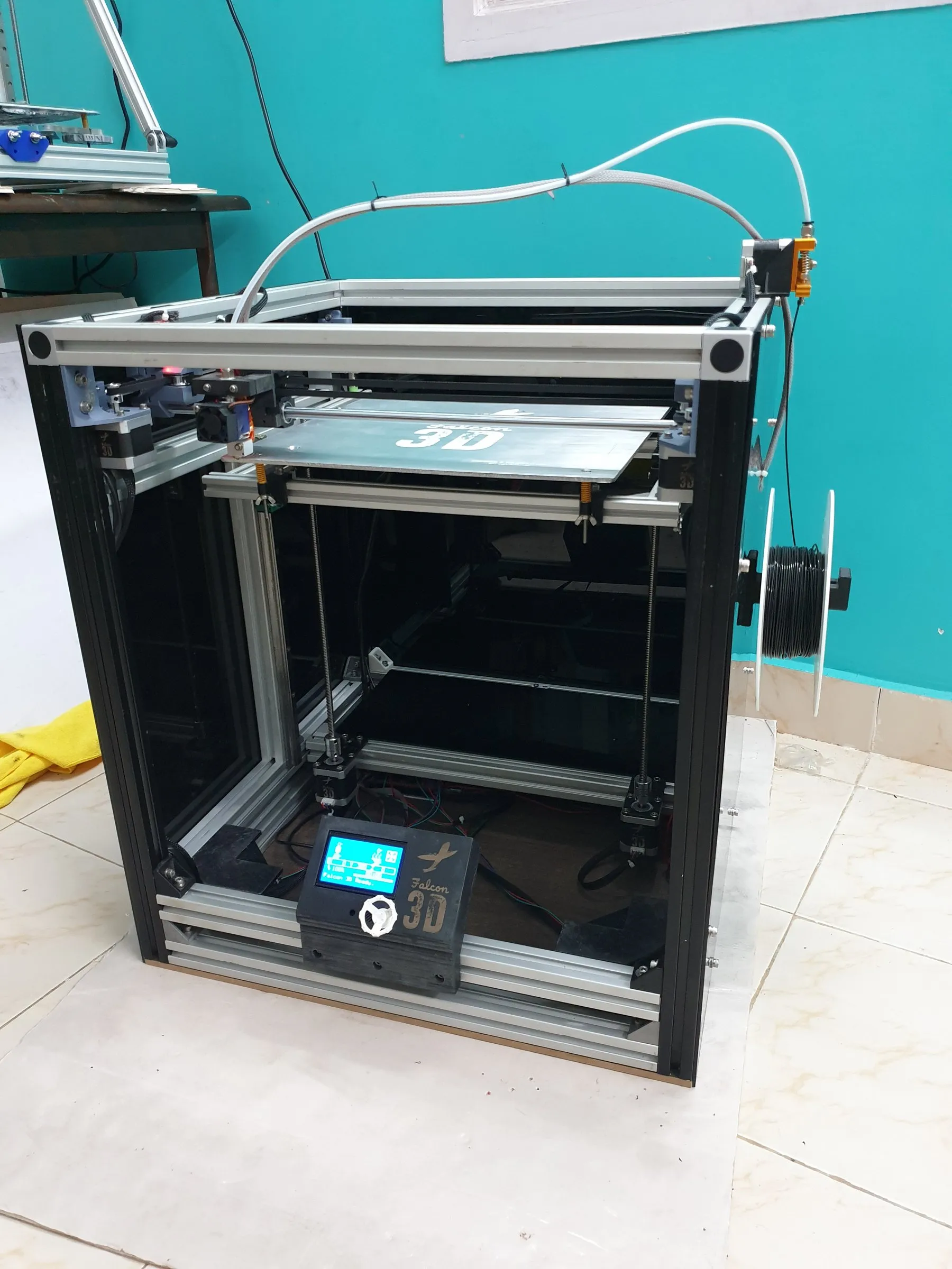 A cube-frame printer with a blue-lit enclosure
