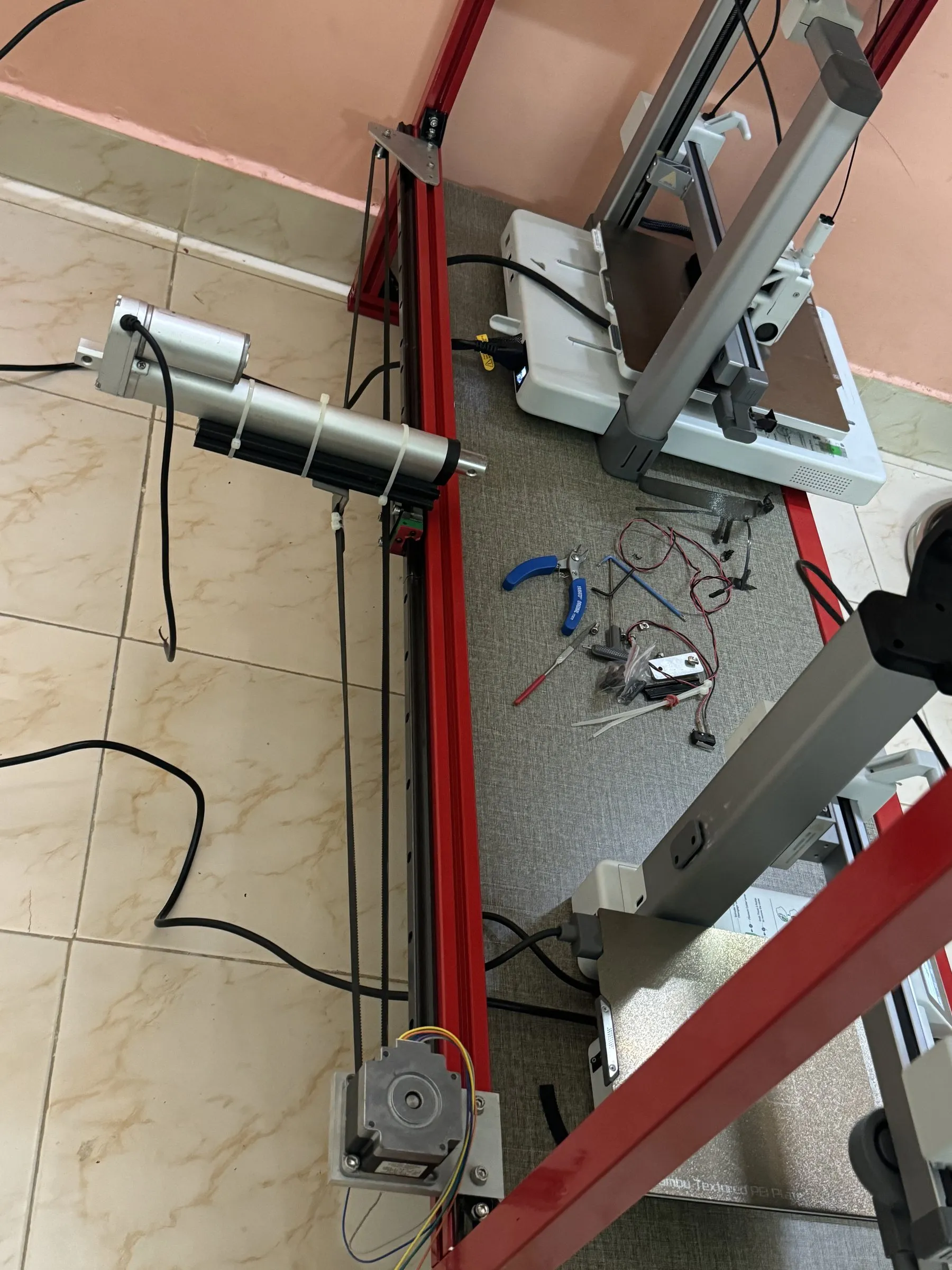 A red printer frame with an automated arm for removing prints