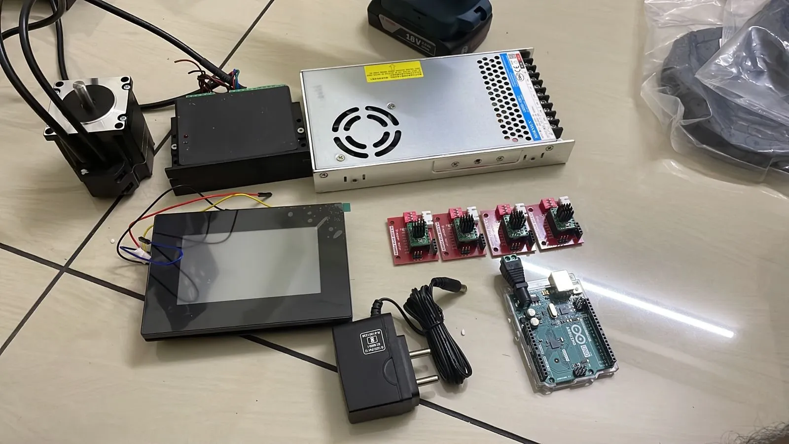 Power supply, stepper drivers, Arduino and touchscreen laid out on a table