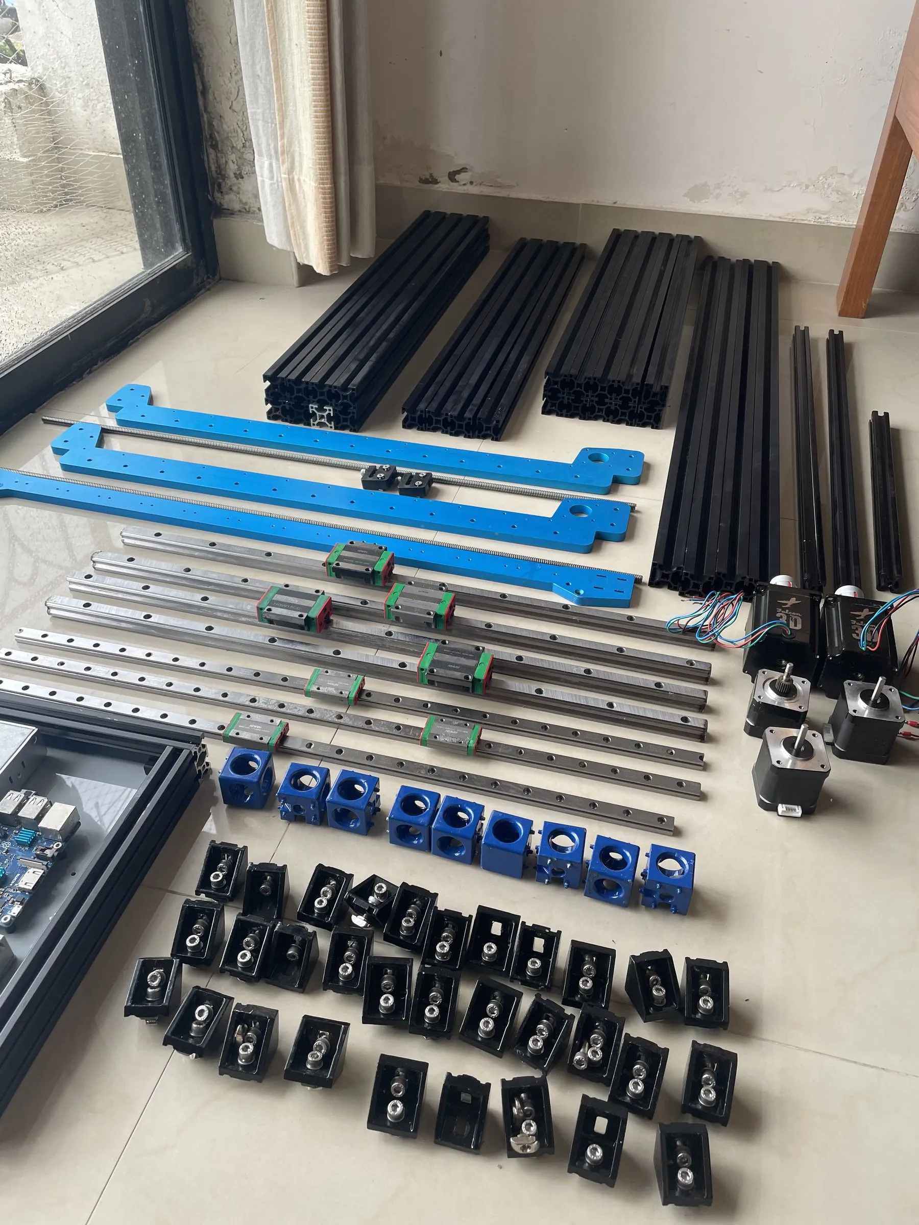Linear rails, extrusions, motors and brackets laid out before assembly