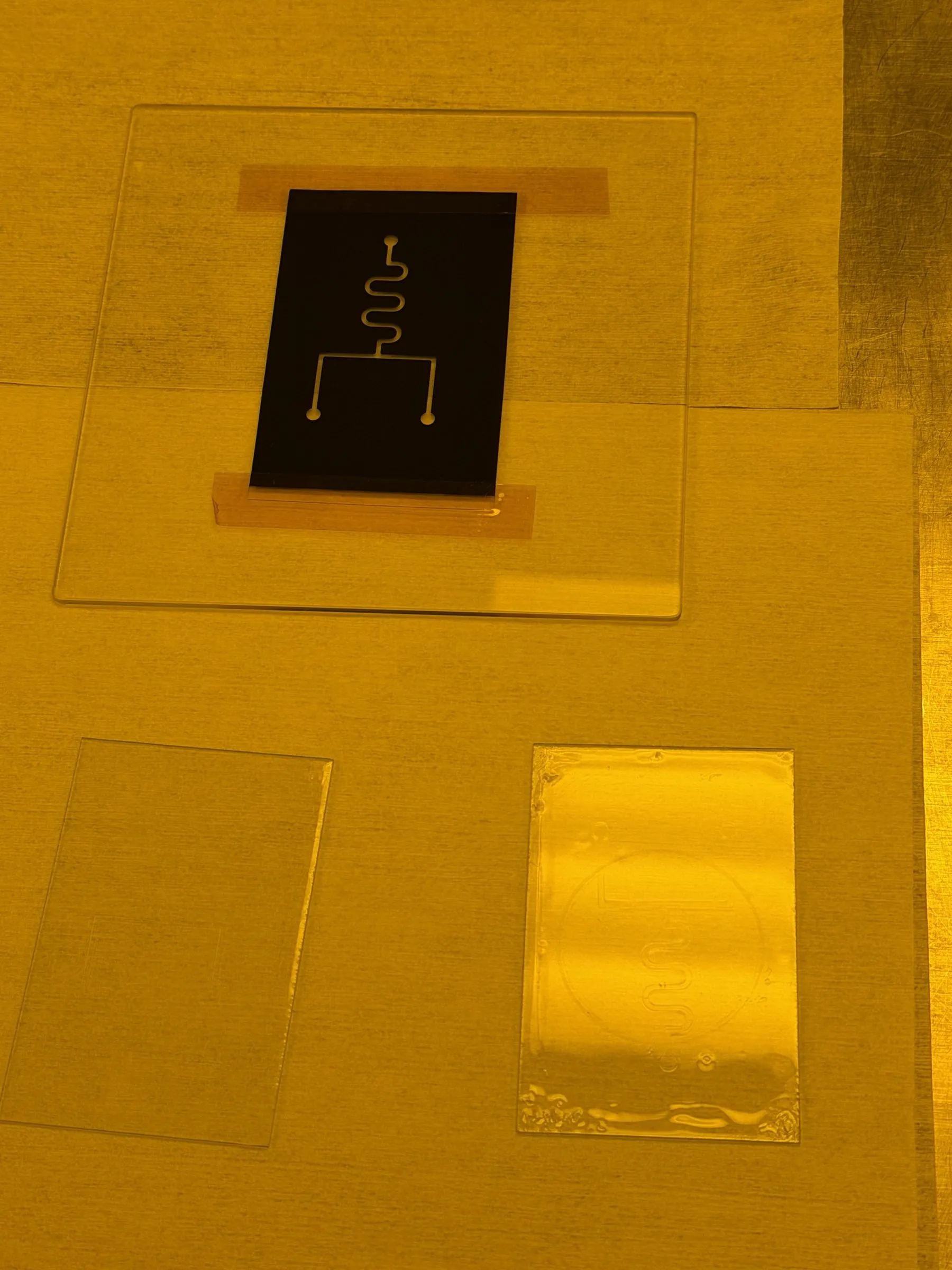 Photomask with the channel pattern on a glass slide, under cleanroom yellow light