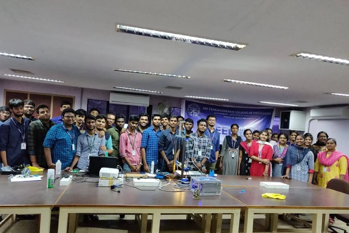 Workshop participants gathered for a group photo in front of an IEEE Student Branch banner, with 3D printers on the tables